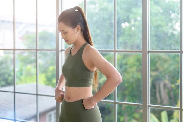 Ritratto di giovane donna in forma che indossa abbigliamento sportivo a casa sport e concetto di stile di vita sano