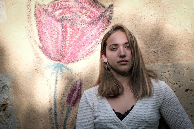 Ritratto di giovane donna in piedi contro il muro