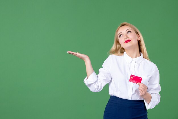 Ritratto di giovane donna in posa con carta di credito parete verde insegnante di scuola denaro bank