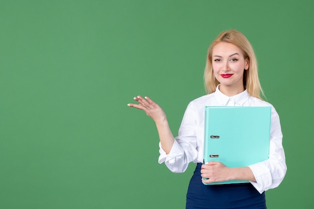 ritratto di giovane donna in possesso di documento parete verde studente lezione di scuola