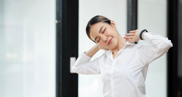 Ritratto di giovane donna in ufficio che fa esercizio di fitness sul posto di lavoro Felice bella donna d'affari che fa la postura di flessione laterale durante il suo tempo di pausa