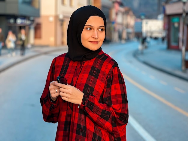 Ritratto di giovane donna musulmana che indossa la sciarpa della testa dell'hijab in città Primo piano volto di donna allegra coperta di velo sorridente all'aperto Casual ragazza islamica in città