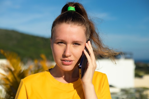 Ritratto di giovane donna positiva bella ragazza felice sta parlando sul suo telefono cellulare cellulare chiamando