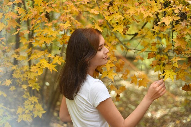 Ritratto di giovane donna russa che guarda l'obbiettivo contro la foresta d'autunno