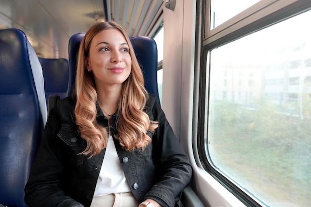 Ritratto di giovane donna soddisfatta che viaggia con i mezzi pubblici seduta rilassata sconsiderata