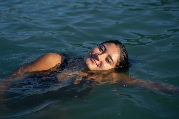 Ritratto di giovane donna sorridente che gode del nuoto