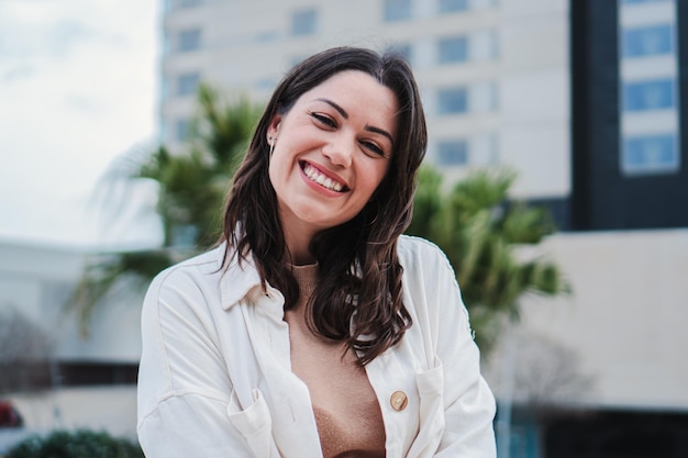 Ritratto di giovane donna sorridente e guardando la fotocamera con dente bianco in piedi all'aperto Vista frontale della ragazza adolescente felice con atteggiamento positivo