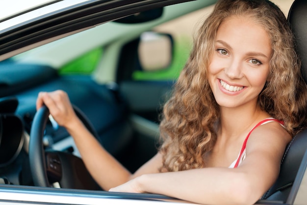 Ritratto di giovane donna sorridente nella sua auto