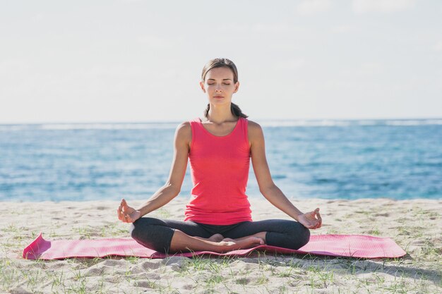 ritratto di giovane donna sportiva che fa meditazione all'aperto