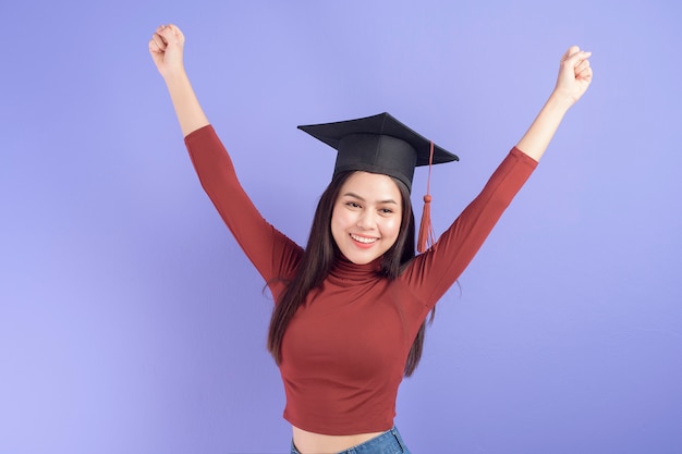 Ritratto di giovane donna studente universitario con cappello di laurea