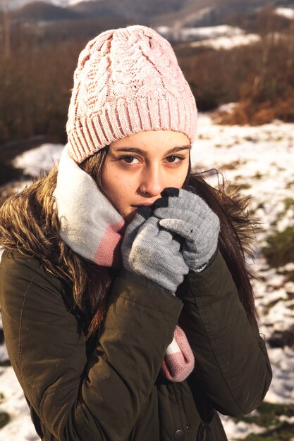 Ritratto di giovane donna su un paesaggio invernale ben avvolto per il freddo