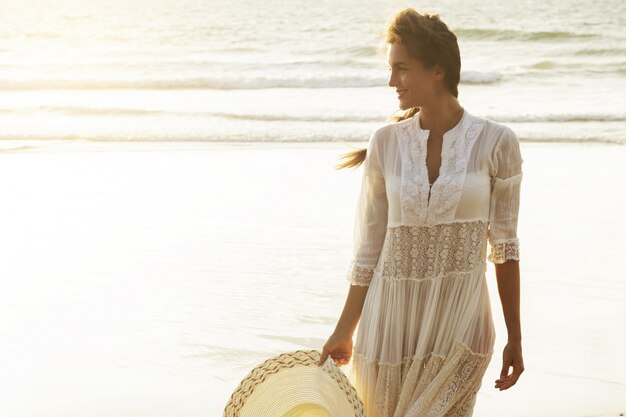 Ritratto di giovane e bella donna con cappello a tesa larga sulla spiaggia