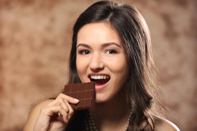 Ritratto di giovane e bella donna con cioccolato da vicino