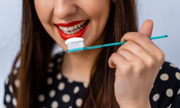 Ritratto di giovane e bella donna con spazzolino da denti in mano. Denti sani e bianchi. concetto dentale.