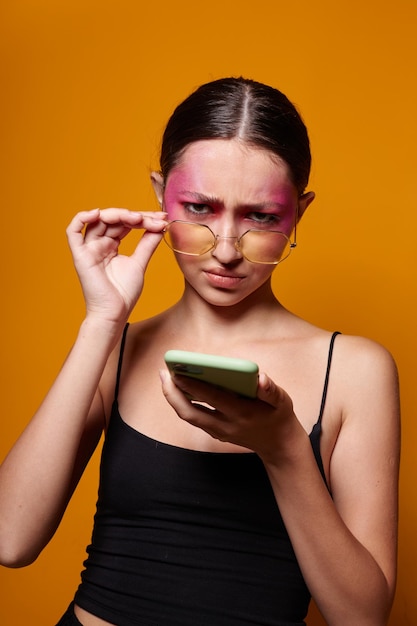 Ritratto di giovane e bella donna con un telefono in mano trucco luminoso in posa emozioni di moda primo piano inalterato