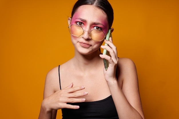 Ritratto di giovane e bella donna con un telefono in mano trucco luminoso in posa emozioni di moda primo piano inalterato