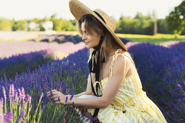 Ritratto di giovane e bella donna in un campo pieno di fiori di lavanda