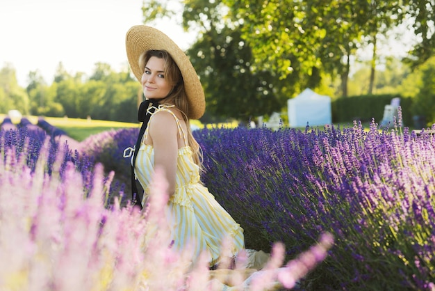 Ritratto di giovane e bella donna in un campo pieno di fiori di lavanda