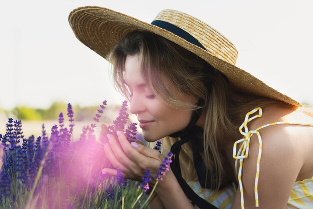 Ritratto di giovane e bella donna in un campo pieno di fiori di lavanda