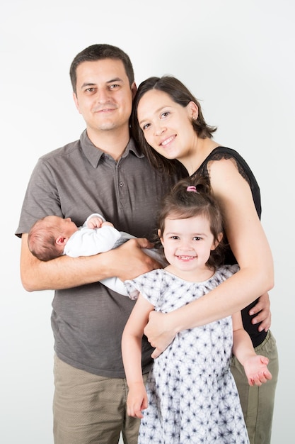 Ritratto di giovane e bella madre figlia padre e figlio neonato che abbraccia guardando la fotocamera e sorridente
