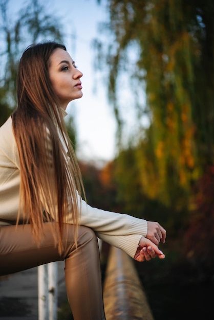 Ritratto di giovane e bella signora seduta sulla natura Stile di vita autunno ragazza rilassante