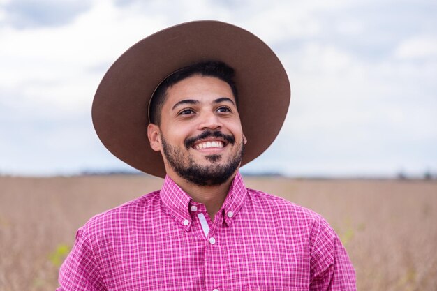 Ritratto di giovane e bello agricoltore maschio sorridente Uomo in fattoria nel giorno d'estate Attività di giardinaggio Uomo brasiliano