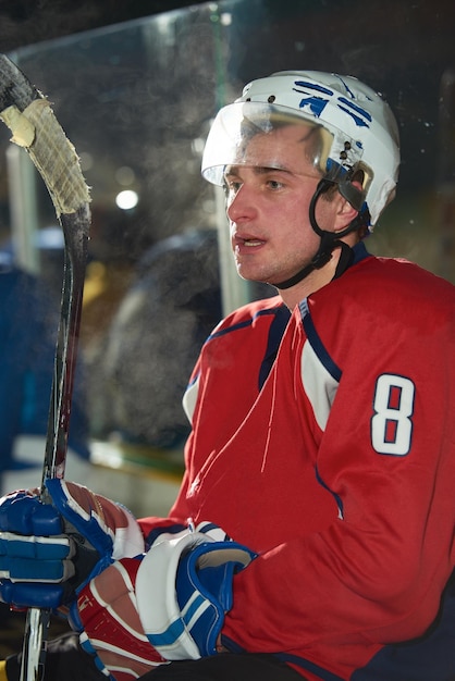 ritratto di giovane giocatore di hockey su ghiaccio sulla formazione in sfondo nero