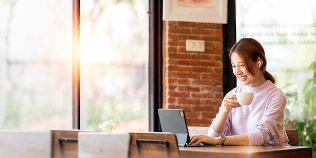 Ritratto di giovane imprenditrice che lavora al computer portatile al caffè Bere caffè e pianificare la sua attività