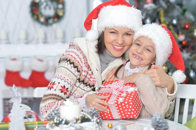 Ritratto di giovane madre e figlia felici con il regalo di Natale