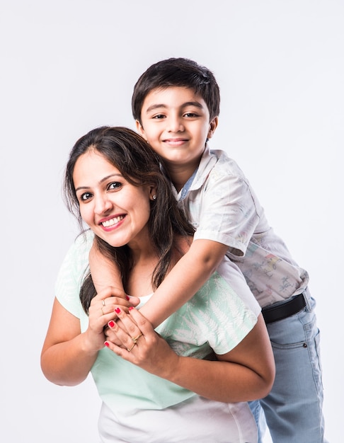 Ritratto di giovane madre e figlio indiani su sfondo bianco, guardando la telecamera