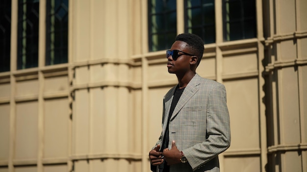 Ritratto di giovane modello di uomo afroamericano alla moda attraente che posa in abiti casual su sfondo neutro che sembra sexy con i capelli afro. In Persone Gioventù Bellezza e concetto di moda.