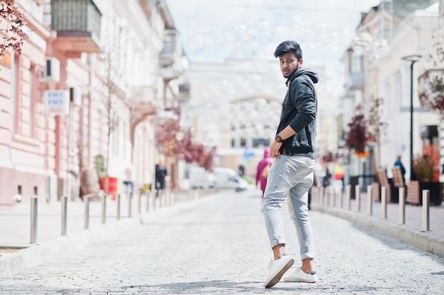 Ritratto di giovane modello indiano alla moda posa in strada.