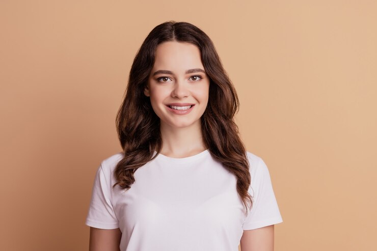 Ritratto di giovane ragazza affascinante sorriso raggiante isolato su sfondo beige