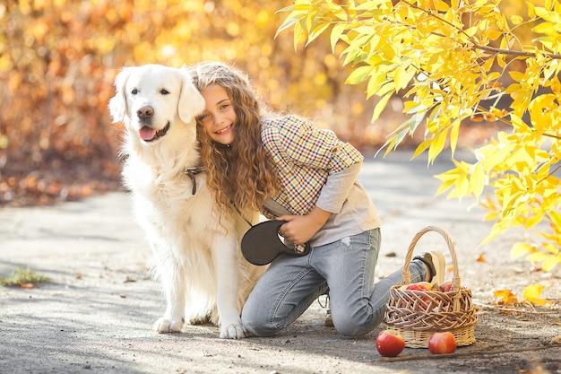 Ritratto di giovane ragazza bionda attraente con cane. Proprietario dell'animale domestico. Golden retriever e il suo proprietario in autunno.