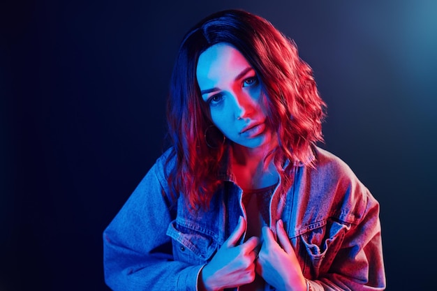 Ritratto di giovane ragazza con i capelli ricci in neon rosso e blu in studio