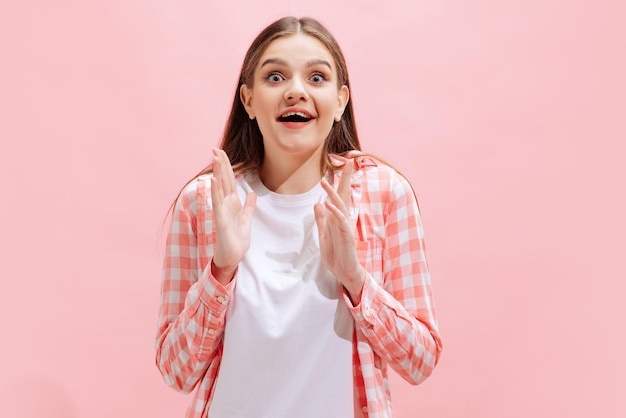 Ritratto di giovane ragazza in camicia a scacchi in posa isolata su sfondo rosa studio emozione di