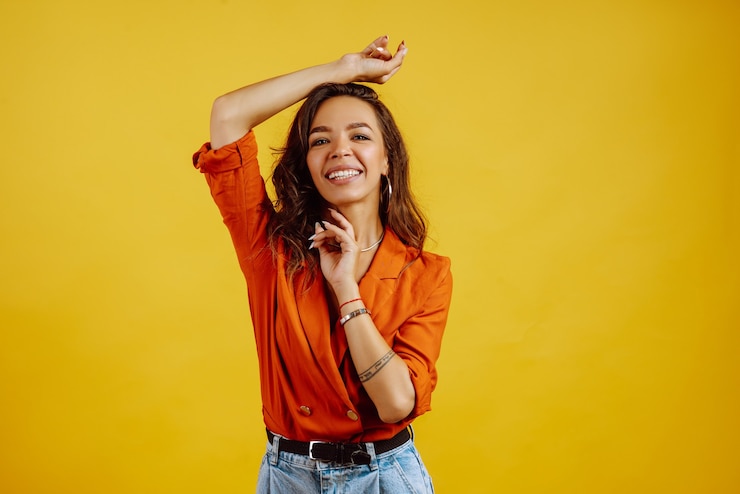 Foto ritratto di giovane ragazza in posa su giallo.