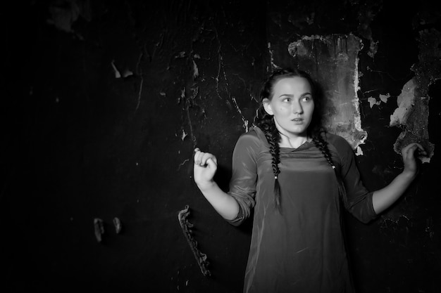 Ritratto di giovane ragazza in una vecchia casa con pareti bruciate