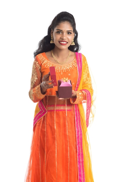 Ritratto di giovane ragazza indiana sorridente felice che tiene i contenitori di regalo su bianco
