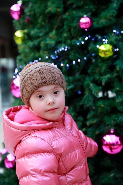 Ritratto di giovane ragazza sullo sfondo dell'albero di natale