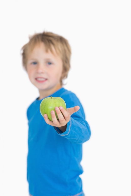 Ritratto di giovane ragazzo che dà una mela verde