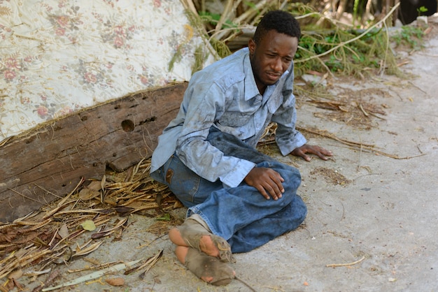 Ritratto di giovane senzatetto uomo africano nelle strade all'aperto