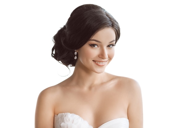 Ritratto di giovane sposa di bellezza con acconciatura di stile e trucco isolato su sfondo bianco studio.