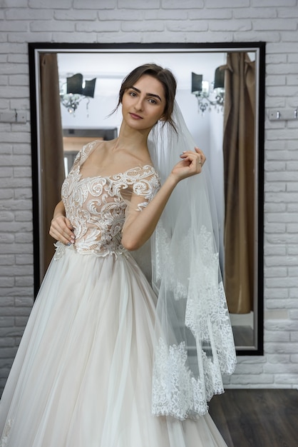 Ritratto di giovane sposa in abito da sposa in negozio