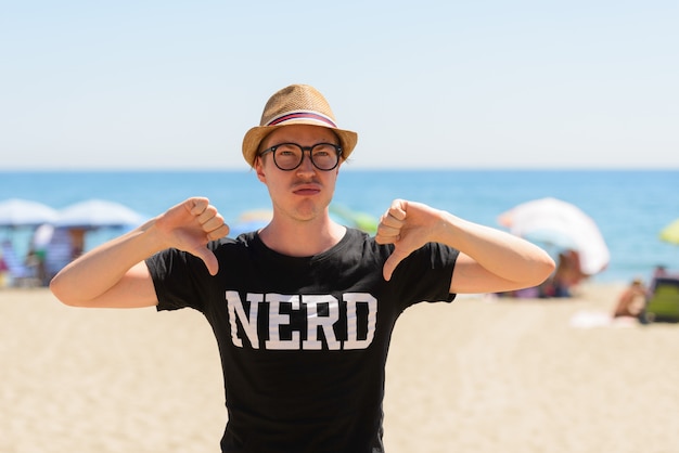 Ritratto di giovane turista bello come nerd in spiaggia in Spagna