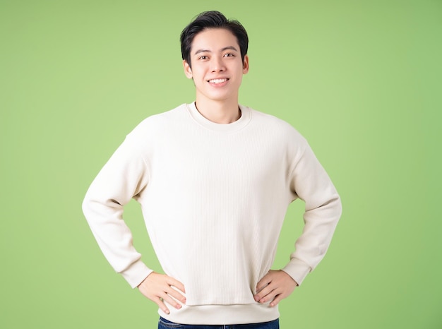 Ritratto di giovane uomo asiatico in posa su sfondo verde