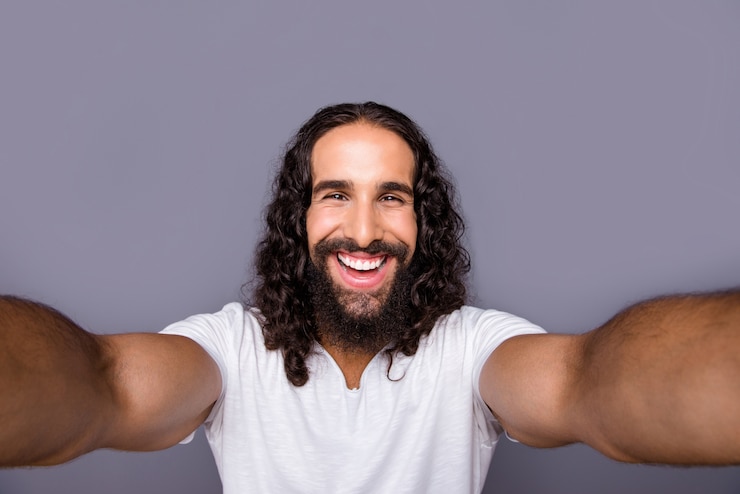 Foto ritratto di giovane uomo con barba e capelli lunghi