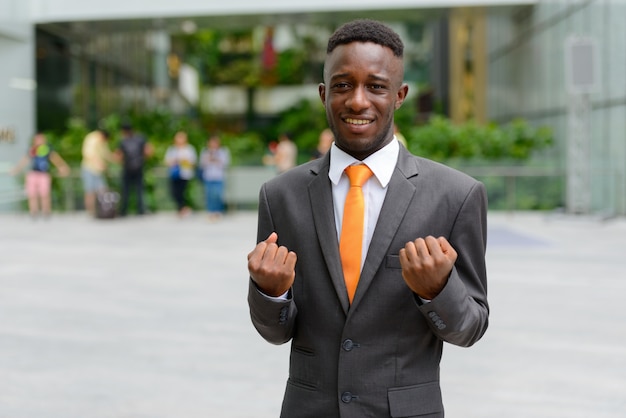 Ritratto di giovane uomo d'affari africano nella città all'aperto