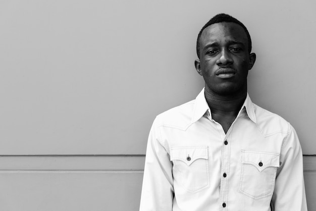 Ritratto di giovane uomo d'affari africano rilassante nelle strade all'aperto in bianco e nero