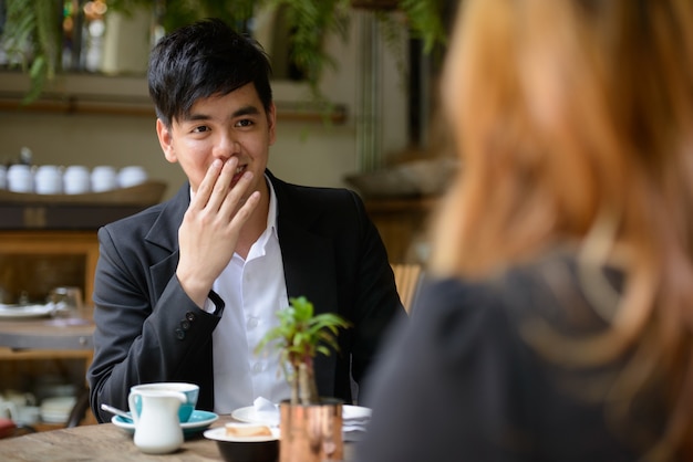 Ritratto di giovane uomo d'affari asiatico e giovane imprenditrice asiatica insieme rilassante presso la caffetteria